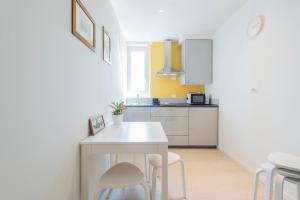 a small kitchen with a white table and chairs at Casa Maglò camere in Verona