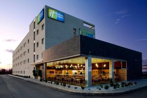 马拉加Holiday Inn Express Málaga Airport by IHG的一座大建筑,里面设有桌椅