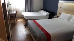 馬拉加的住宿－Holiday Inn Express Málaga Airport, an IHG Hotel，酒店客房设有两张床和一张桌子。
