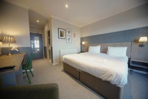 Habitación de hotel con cama grande y escritorio. en Highfield Hotel en Houghton le Spring