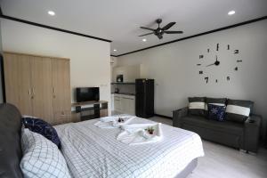 1 dormitorio con 1 cama y reloj en la pared en MB House Resort en Ban Nai Rai