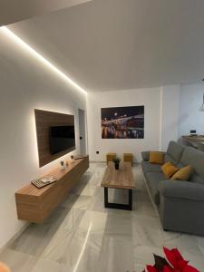 a living room with a couch and a tv at WISH SUITE PONCE DE LEON in Seville
