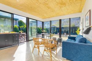een woonkamer met een blauwe bank en een tafel bij Blackhaus A B Buyout by AvantStay Sleeps 16 in Palm Springs