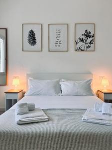a bedroom with a white bed with towels on it at Villa Noga Rooms in Selargius