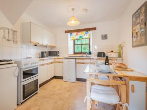 a kitchen with white appliances and a wooden table at 2 Bed in Mosedale SZ218 in Mosedale