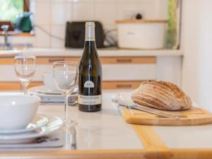 a bottle of wine and a loaf of bread on a table at 2 Bed in Mosedale SZ218 in Mosedale