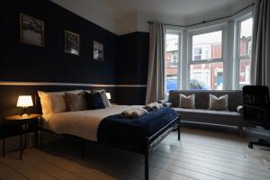 a bedroom with a bed and a couch at Centrally Located Stylish Flat in Jesmond