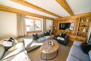 ein Wohnzimmer mit 2 Sofas und einem Tisch in der Unterkunft Seven Alpina Boutique Hotel in Klosters Serneus