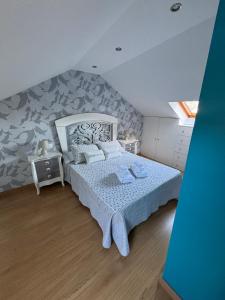 1 dormitorio con 1 cama con colcha azul y blanca en Casa Lalo, en Camariñas