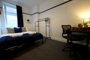 a bedroom with a bed and a desk and a chair at Centrally Located Stylish Flat in Jesmond