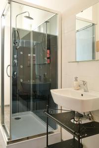 a bathroom with a glass shower and a sink at Stodolní Apartment in Ostrava