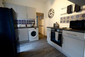 uma cozinha com uma máquina de lavar roupa e uma máquina de lavar roupa em Centrally Located Stylish Flat em Jesmond