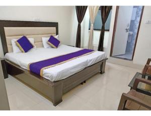 a bedroom with a large bed with purple pillows at Hotel Radhika Kunj Palace, Chhatarpur in Chhatarpur