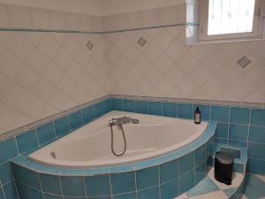 eine Badewanne im Bad mit blauen Fliesen in der Unterkunft Gite Meuz' Friendly 