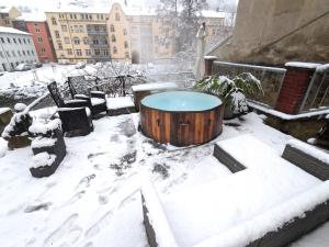 a snow covered patio with a table and benches at Urlaubsmagie - Sauna, (Whirl)-Pool & Garten - F2 in Sebnitz
