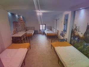 pokój z 2 łóżkami, stołami i krzesłami w obiekcie Łódzki Pałacyk - Pokoje hostelowe w Łodzi