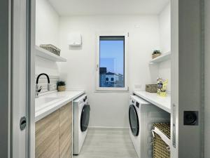a laundry room with a sink and a washing machine at Villa Noga Rooms in Selargius