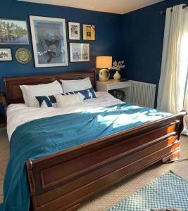 a bedroom with a bed with a blue wall at Large 4 bed house in Malmesbury, great for big families in Malmesbury