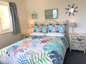 une chambre avec un lit avec une couette colorée dans l'établissement 4 Bed in Ventnor oc-ic169, à Ventnor
