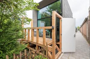 een huis met glazen deuren en een houten terras bij KODA Edam in Edam