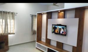 a tv on a wall in a living room at AVM Paradise in Yelagiri