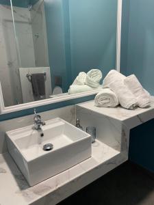 a bathroom with a sink and a mirror and towels at PARASIOU STUDIOS 103 διαμερίσματα στο κέντρο της πόλης in Komotini