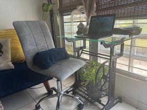 a desk with a chair and a laptop on a table at MI CASITA BOHO GREEN in Guayama