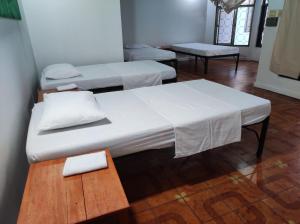 a room with three beds and a table and a table sidx sidx at LETICIAS GUEST HOUSE in Leticia