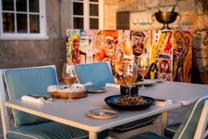 una mesa con copas de vino y un tazón de comida en Maison Bleue, en Oporto