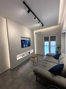 sala de estar con sofá y TV en la pared en Central Stylish Lux Apartments en Lamía