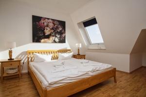 1 dormitorio con 1 cama y una pintura en la pared en Hafenhäuser Breege FeWo 06 - Balkon, Meerblick, en Breege