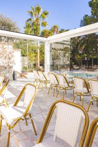 a group of chairs sitting on a patio at Hôtel Le Sud in Juan-les-Pins