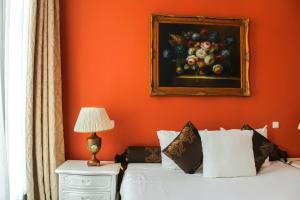 フローニンゲンにあるホテル スヒンメルペニンク ヒュイスのフルーツの絵が描かれたオレンジ色の壁のベッドルーム