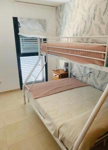 a bedroom with two bunk beds and a window at ALCOSSEBRe VILLA DULCINEA 2023 in Alcossebre