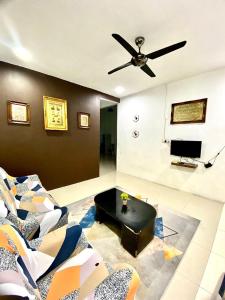 sala de estar con ventilador de techo y sofá en Casaria Homestay Paka, en Paka