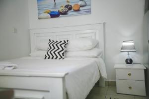 una camera bianca con letto bianco e cuscini di Eagle Nest furnished studio apartments at Eagle Tower. a Nairobi