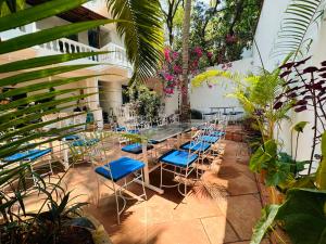 a patio with blue chairs and tables and plants at Oceanic - Luxury Boutique Hotel in Palolem