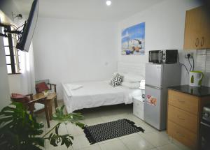 una piccola cucina con letto e frigorifero di Eagle Nest furnished studio apartments at Eagle Tower. a Nairobi