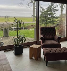 sala de estar con sofá, silla y ventana en Luxury Villa Stay en Waddinxveen