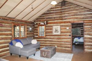 - un salon avec un canapé dans une cabane en rondins dans l'établissement Russell Cabin, à Logan