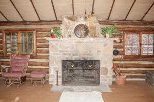 a living room with a stone fireplace in a log cabin at Russell Cabin in Logan
