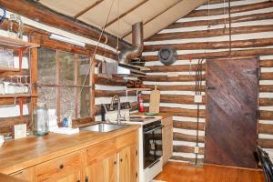 a kitchen with wooden walls and a sink and a stove at Russell Cabin in Logan