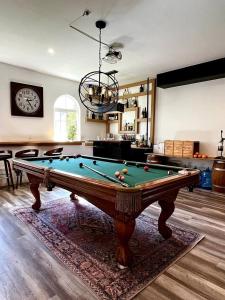 a living room with a pool table and a clock at Mediterranean Villa Pool & Jacuzzi & BBQ Malibu & Hollywood Bliss in Los Angeles