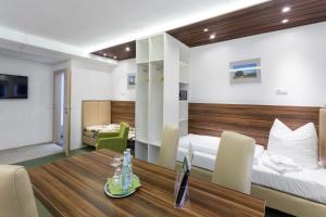 ein Hotelzimmer mit einem Bett und einem Esstisch in der Unterkunft Hotel Alea City in Pfaffenhofen an der Ilm