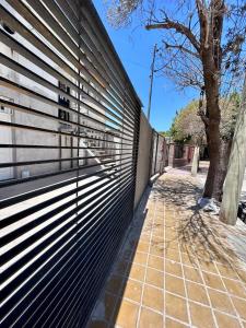 a fence with metal slats on the side of a building at Güemes Apart in San Juan