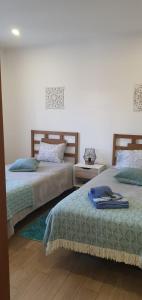 two beds sitting next to each other in a bedroom at Casa Isa in Almograve