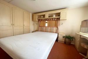 a bedroom with a large white bed in a room at Knus chalet, De Nollen P12 in Callantsoog