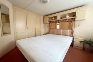 a bedroom with a large white bed in a room at Knus chalet, De Nollen P12 in Callantsoog