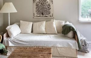 um sofá com almofadas brancas numa sala de estar em Stunning Home In Undens With House Sea View em Undenäs