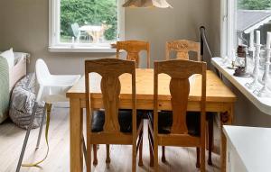 uma mesa de jantar com quatro cadeiras à volta em Stunning Home In Undens With House Sea View em Undenäs